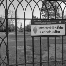 Foto zeigt den Eingang des Südfriedhofs und die Aufschrift "immaterielles Erbe Friedhofskultur".