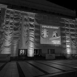 Vor der Oper in Leipzig wird das neue Logo von der Spielstätte Leipzig bei der EM 2024 an die Wand geworfen