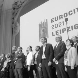 Auf dem Bild sind die Bürgermeister:innen zu sehen und posieren vor einer Leinwand für Pressefotos