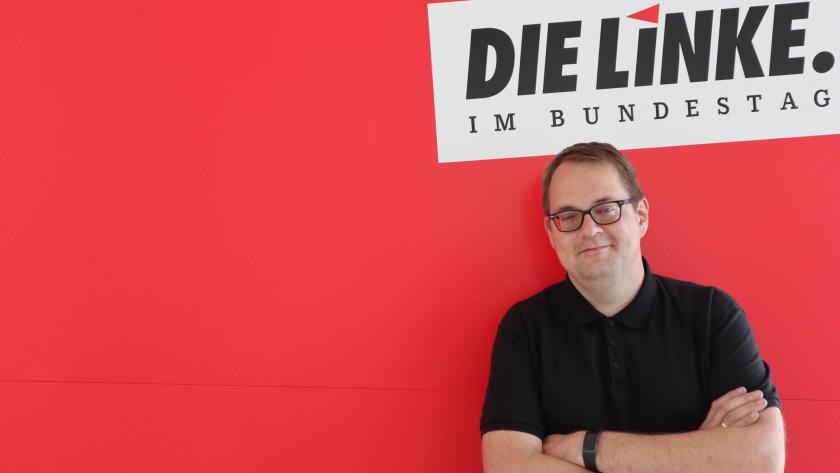 Der Bundestagsabgeordnete Sören Pellmann steht vor rotem Grund und unter dem Logo der Linken.