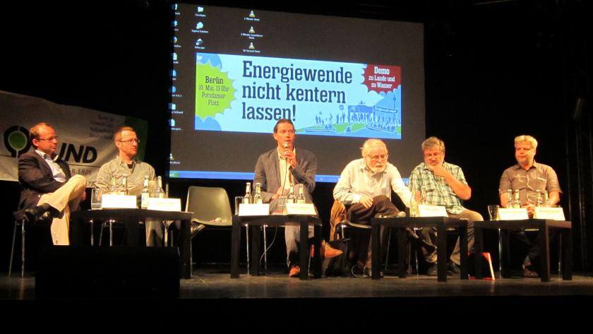 Sechs Menschen sitzen auf einer Bühne und diskutieren