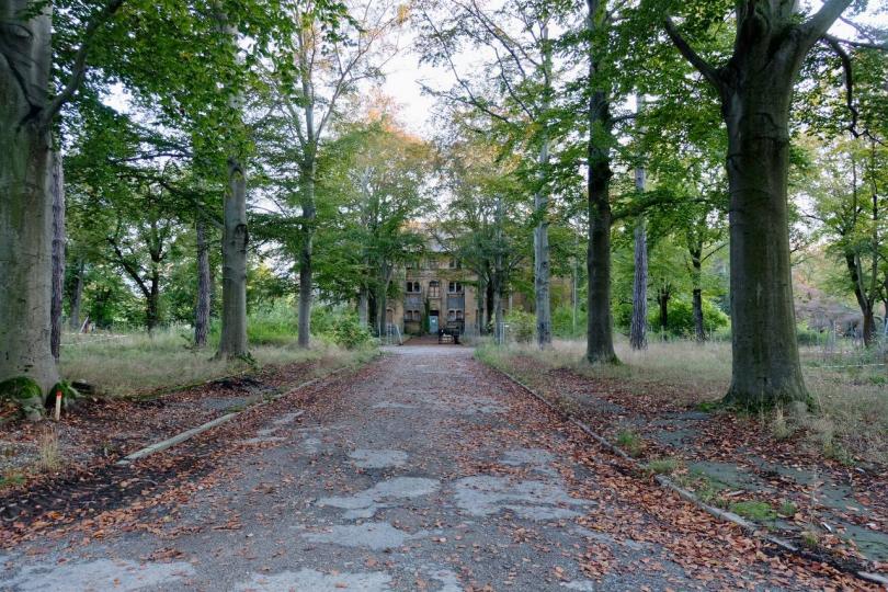 Parkähnliches Gelände mit ehemaligem Patient*innengebäude